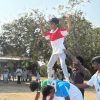 School children performing group balancing activity during outdoor sports event